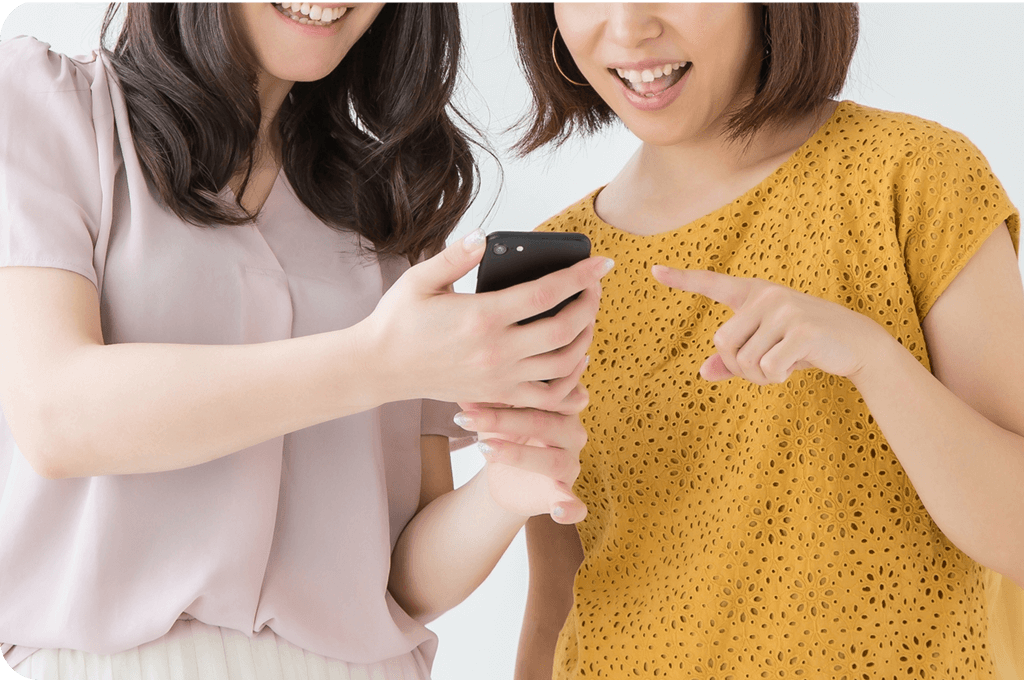 スマホを見て喜ぶ女性たち